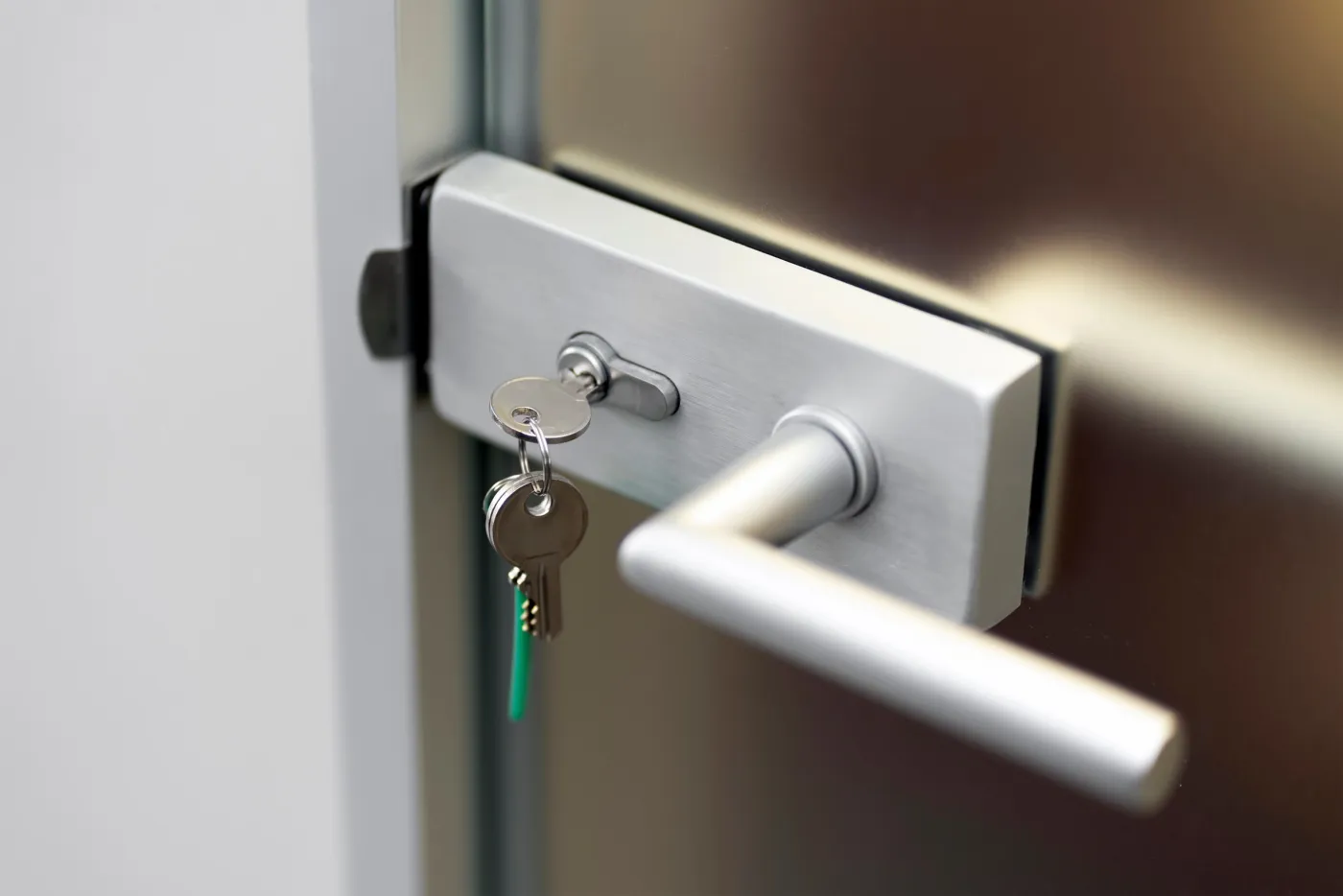 Poignée chromée et clés sur une porte d'entrée dans le Val-d'Oise